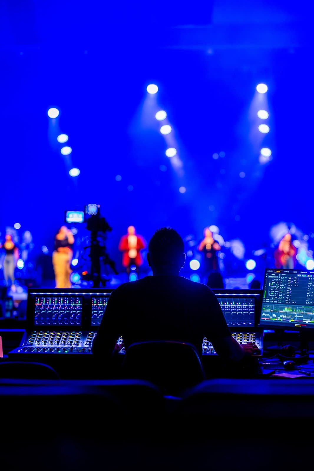 Concert-style stage production with blue lighting