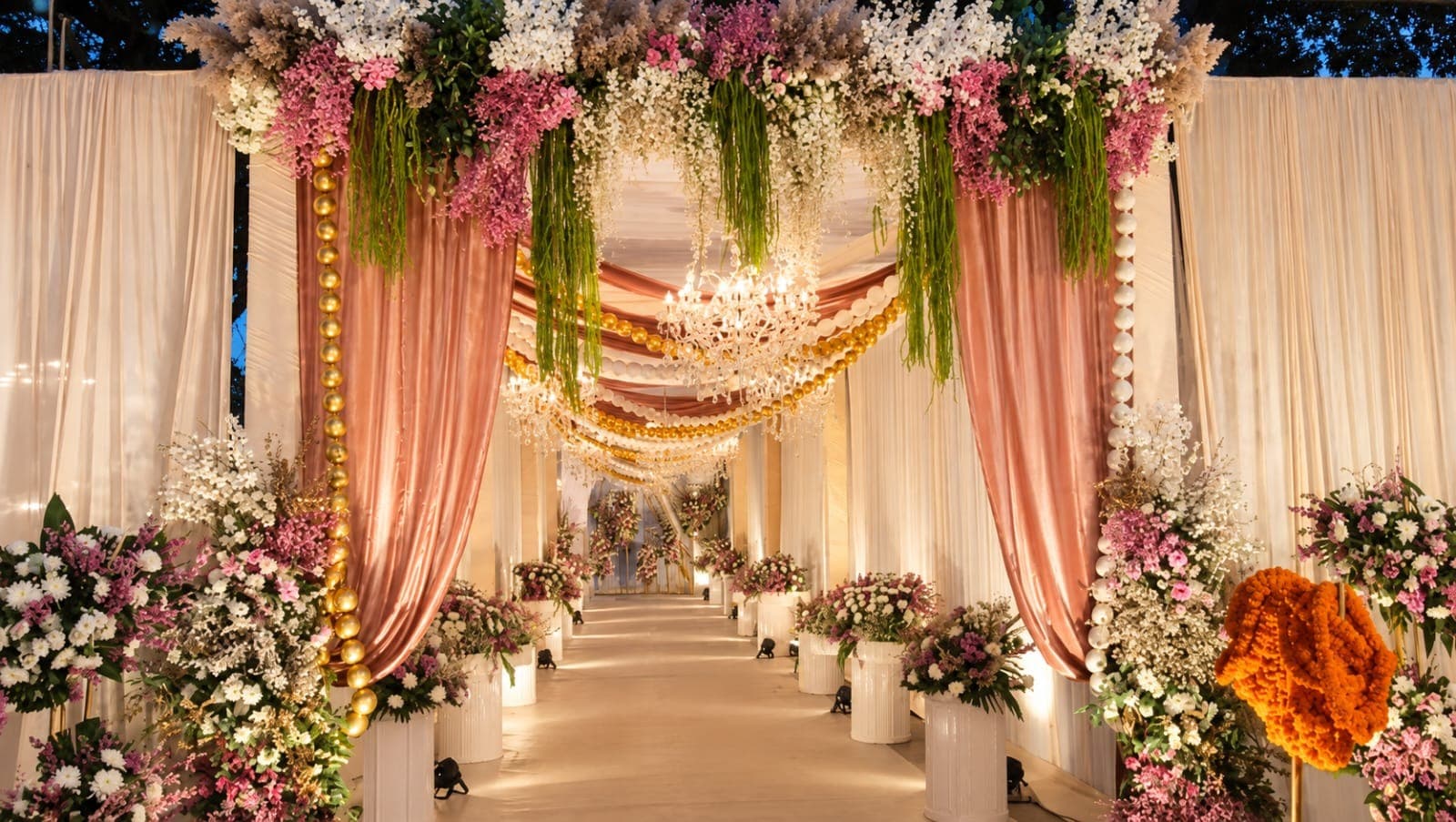 Blush and ivory draped reception walkway with chandeliers