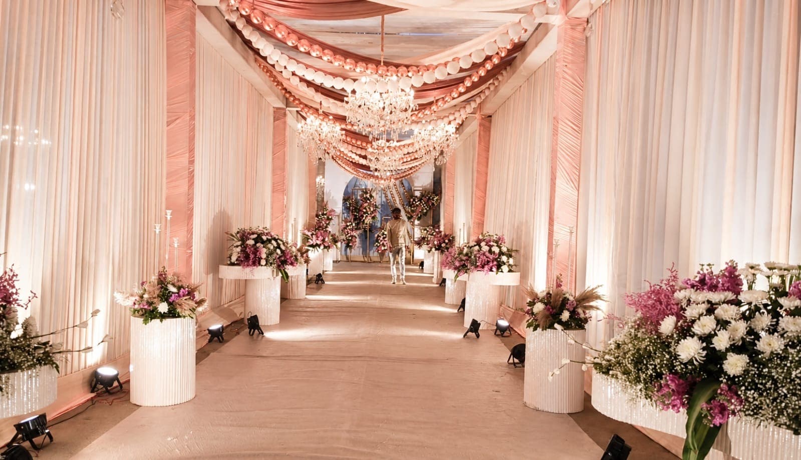 Guest walking through a rose gold reception corridor