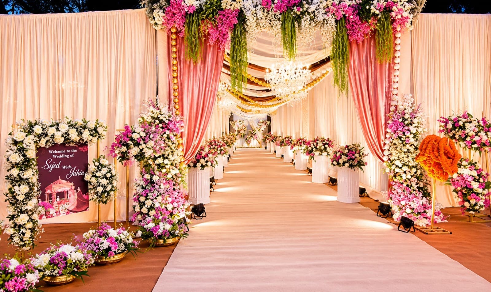 Welcome signage framed by pink and white floral arrangements