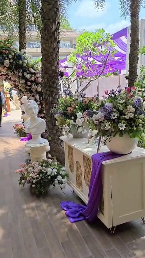 Classical statuary and floral arrangement under palm trees
