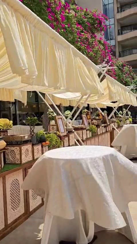 Ivory drapes and bougainvillea over a reception dining table
