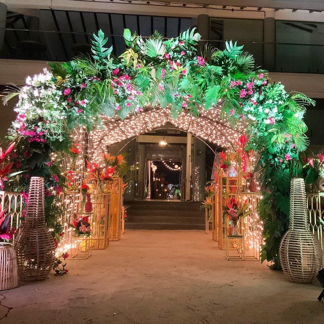 Tropical floral archway entrance with hanging greenery