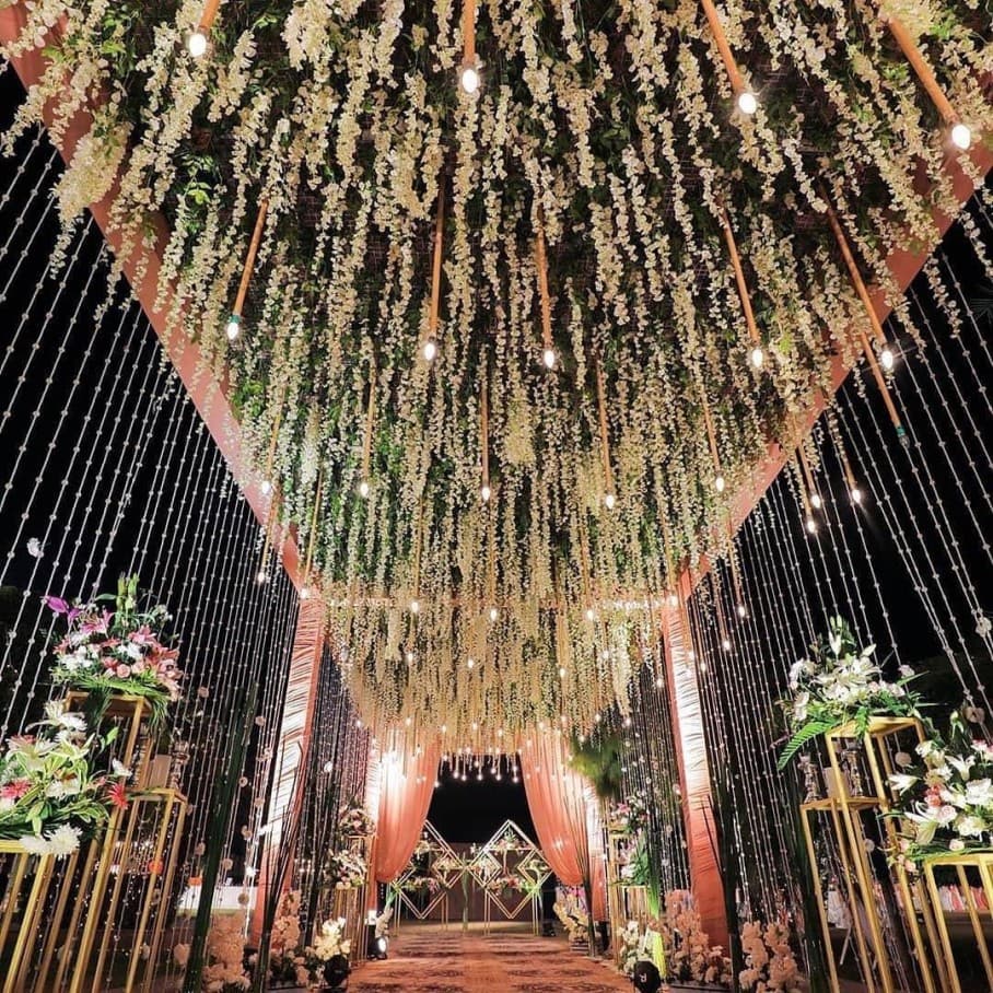 Candlelit dining table beneath a string-light pergola