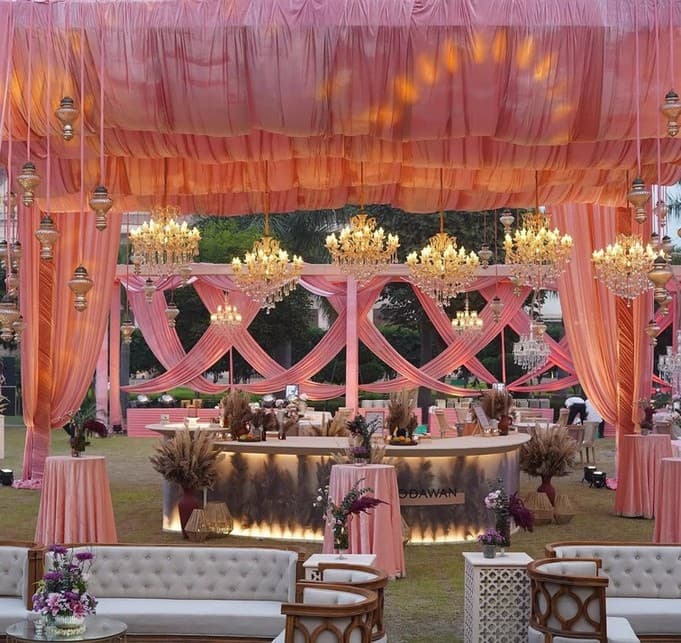 Blush pink reception lounge with crystal chandeliers