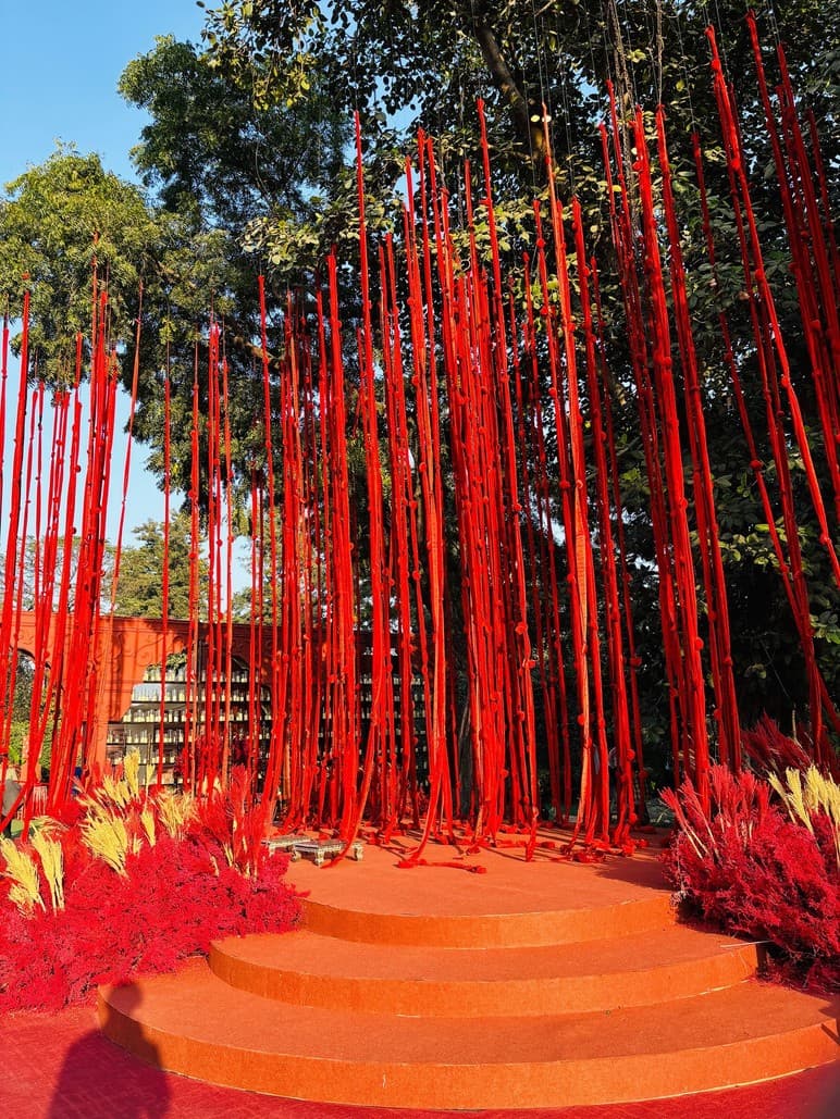 Red ribbon art installation lining a garden pathway